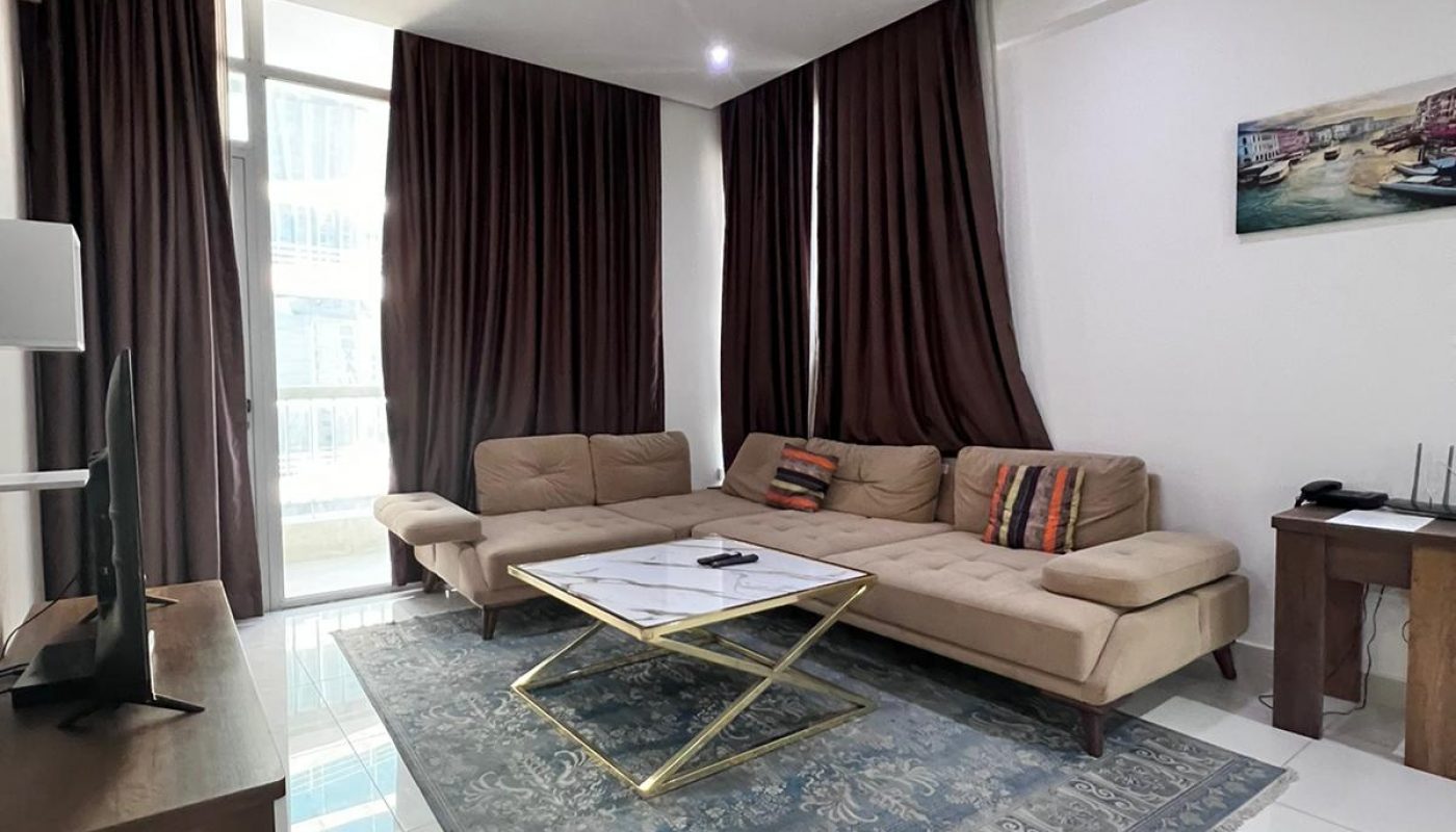 A modern living room in a luxury apartment with a flat screen tv and a coffee table.