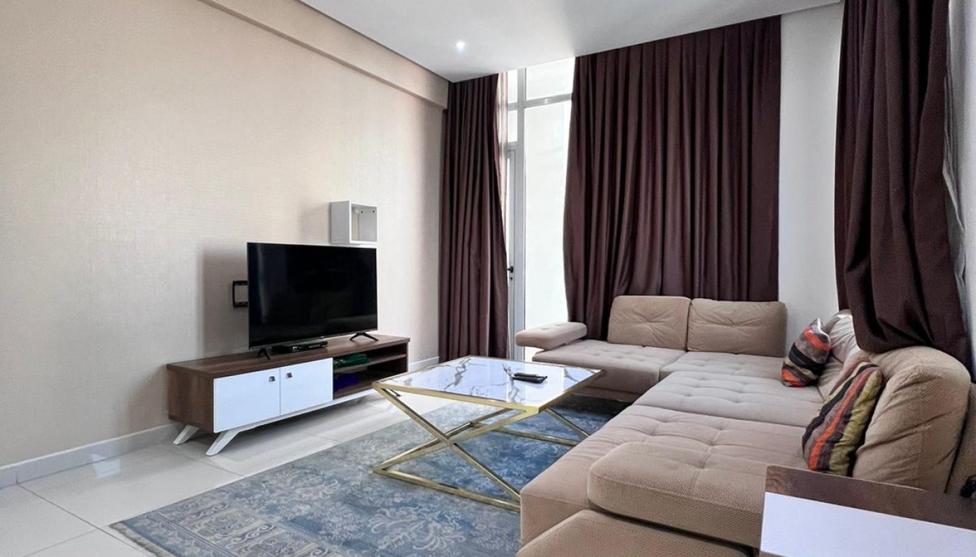 A modern living room in a luxury apartment with a flat screen TV and a couch.