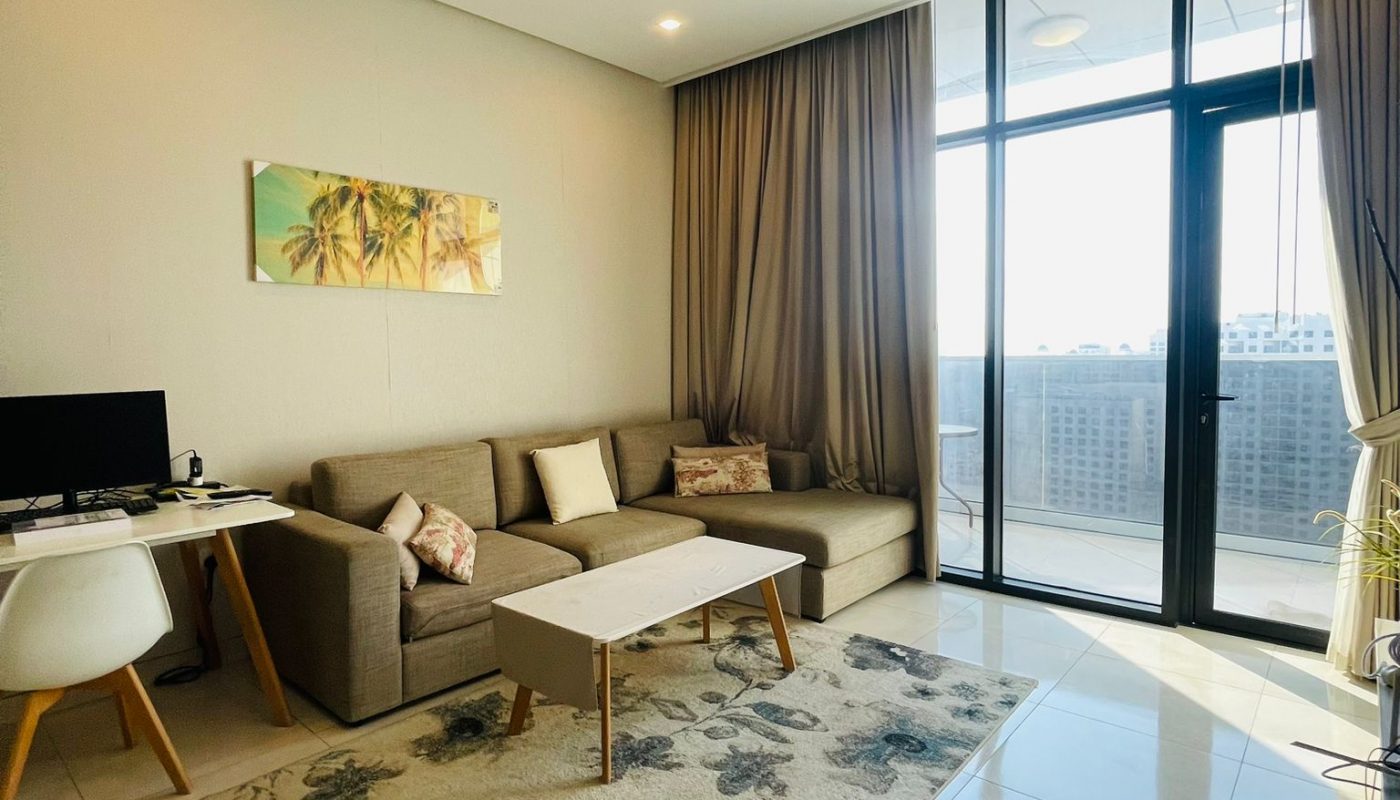 A modern living room with a flat screen TV and a balcony in a luxury apartment.