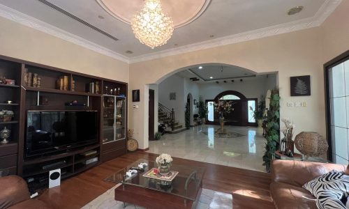 A living room with leather furniture and a chandelier.