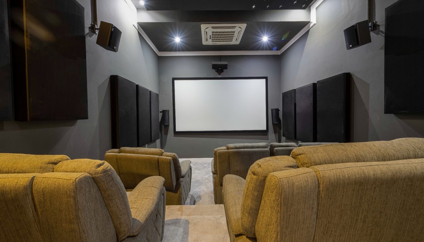 غرفة مسرح منزلي فاخرة مع كراسي قابلة للتمدد وشاشة عرض، مثالية لشقة من نوع الاستوديو.