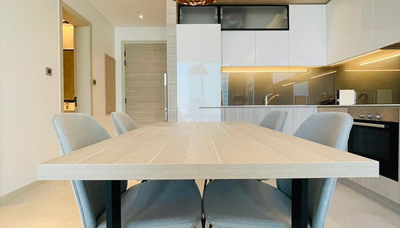 A modern kitchen with a wooden table and chairs.