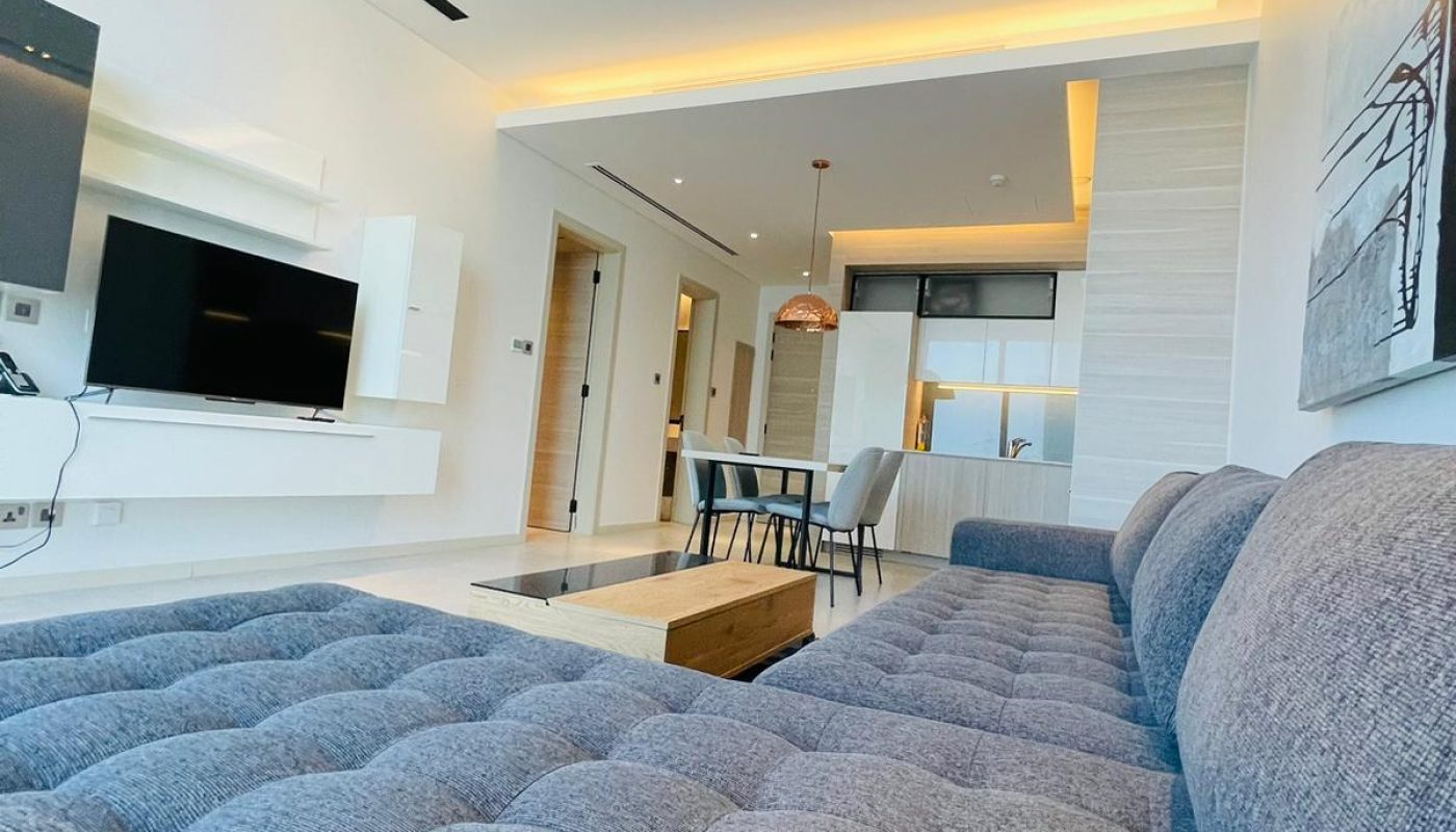 A living room with a blue couch and tv.