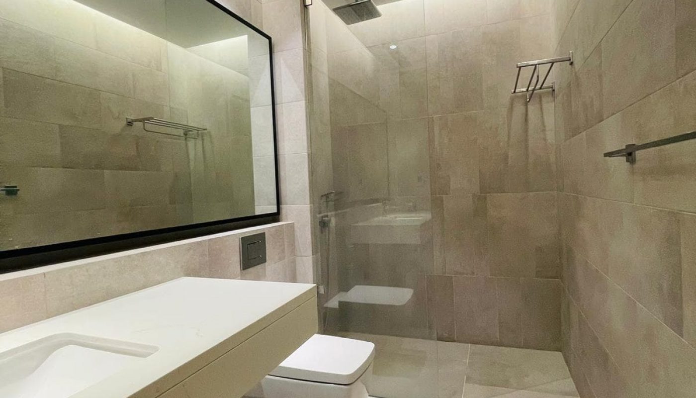 A modern bathroom with a white sink and mirror.