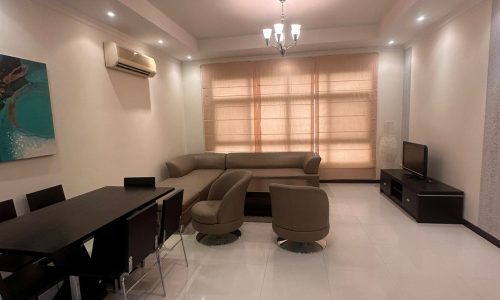 A modern living room with a dining table and chairs.