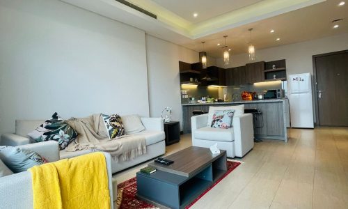 A luxury 1 BR apartment in Seef featuring a living room with a couch and a coffee table.