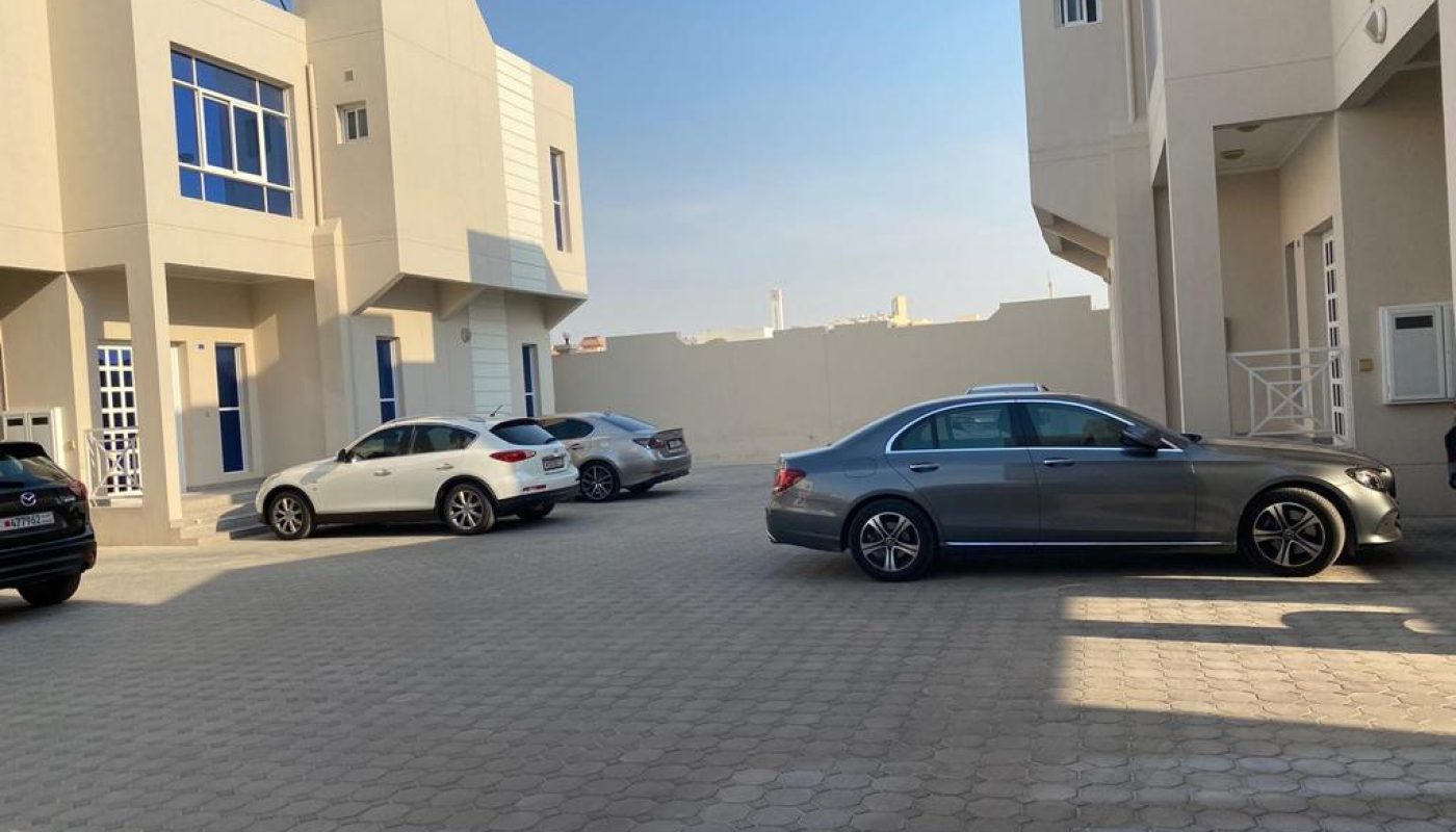 Two cars parked in front of a building.