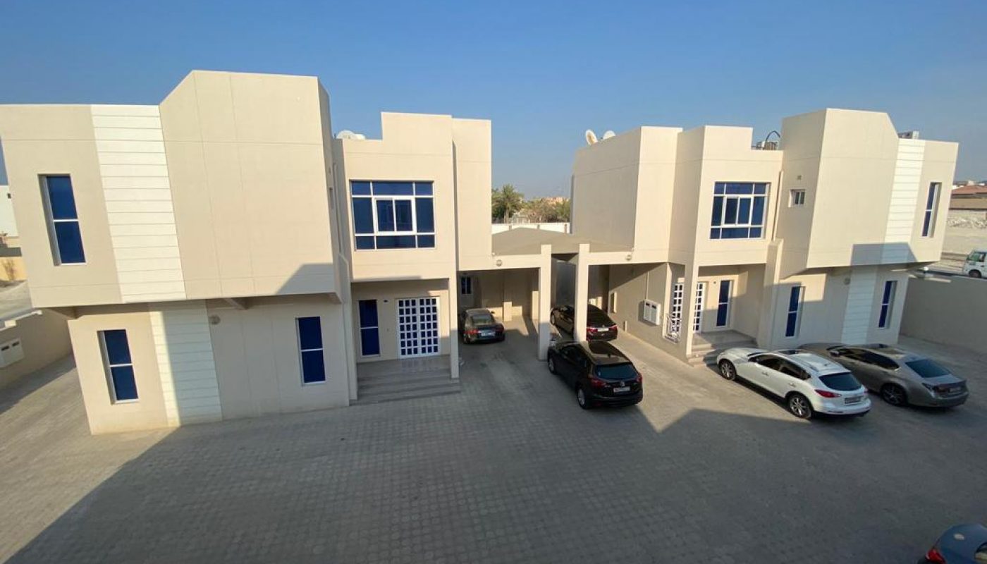 A white building with cars parked in front of it.