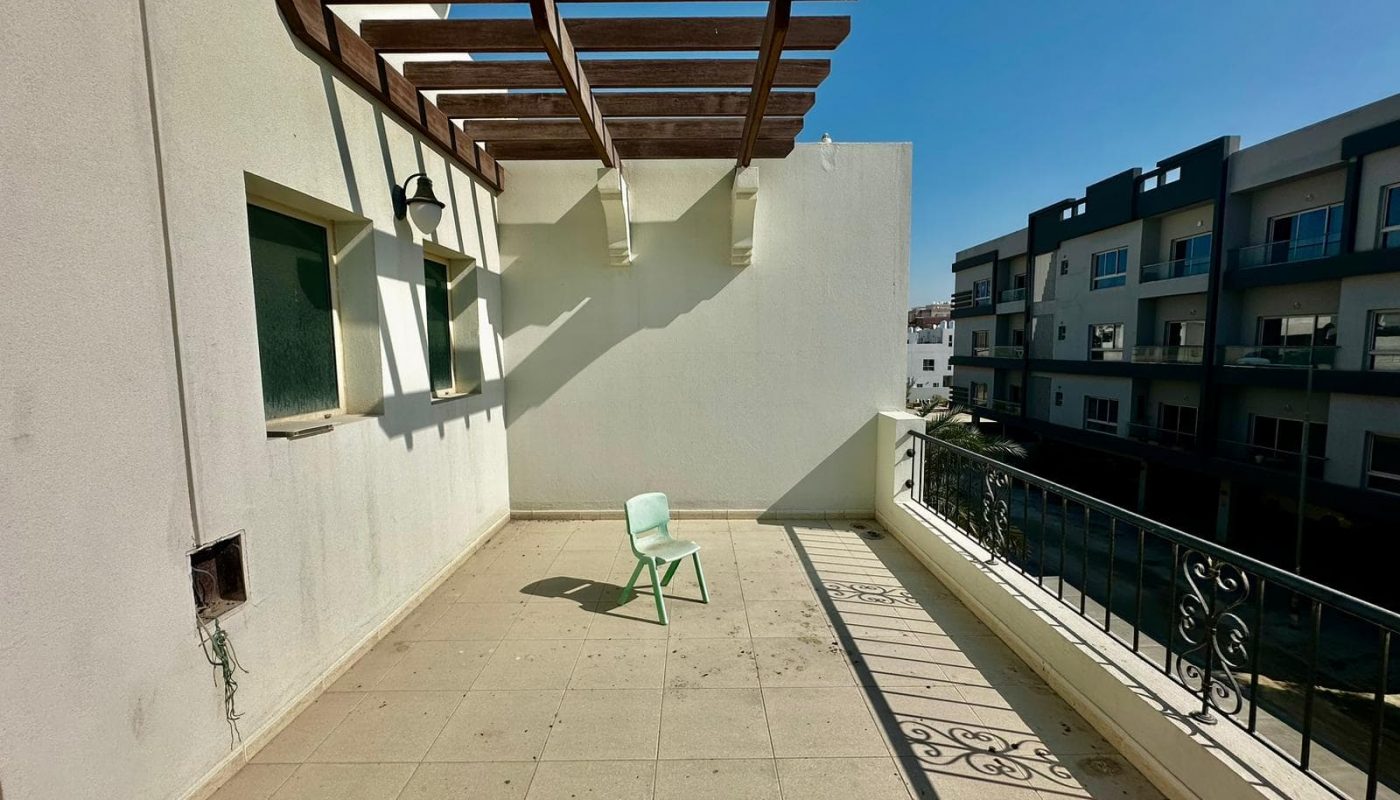 A luxury villa with a balcony and a chair.