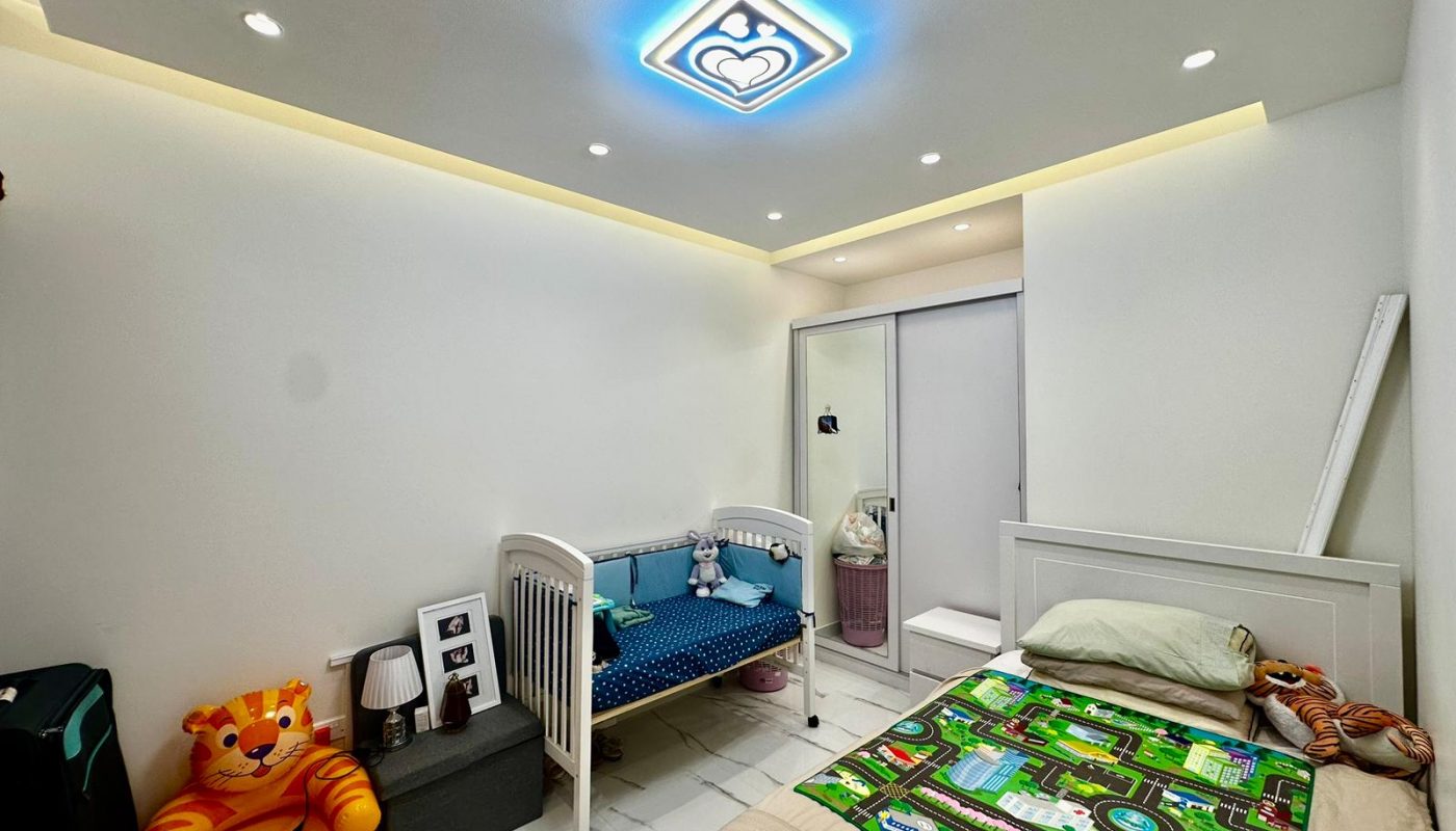 A child's room with a bed and a teddy bear in a private villa.