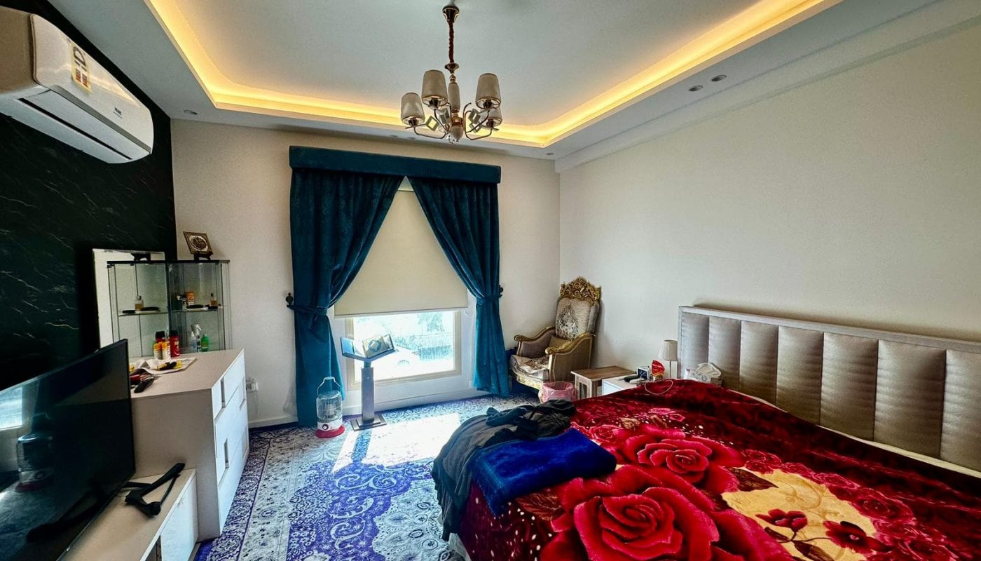 A modern bedroom with a luxury bed and a TV.