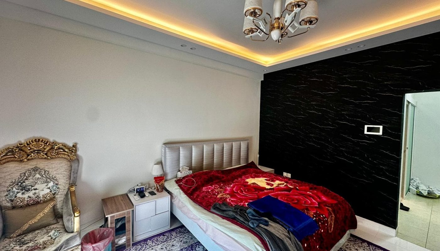 A Janabiyah bedroom featuring a luxurious bed and elegant chandelier.