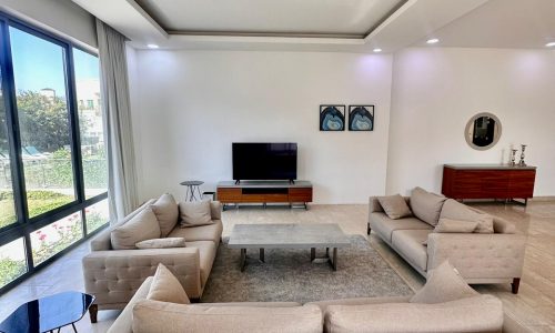 A living room with couches and a flat screen tv.