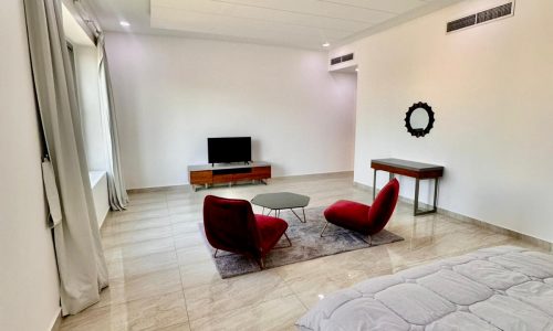 A modern bedroom with a bed and a television.