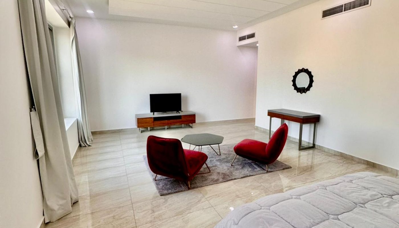 A modern bedroom with a bed and a television.