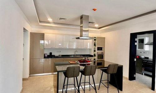 A kitchen with a bar area and a dining table.