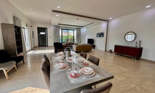 A living room with a dining table and chairs.