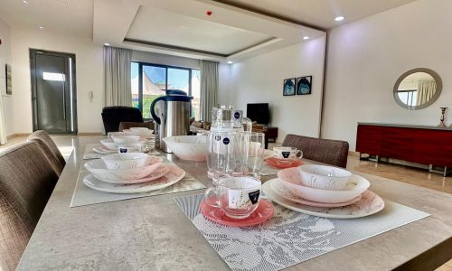 A dining room with a large table and chairs.