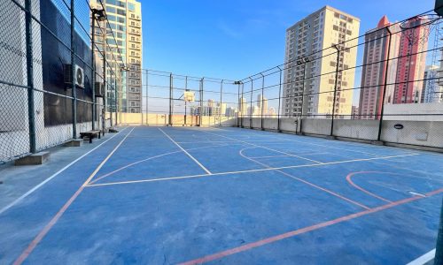 A basketball court surrounded by luxurious residential towers in the middle of JUFFAIR, offering the perfect setting for a dream apartment.