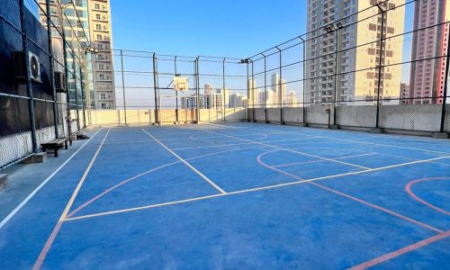 A luxurious basketball court situated in the heart of Juffair, surrounded by stunning residential towers and apartment complexes.