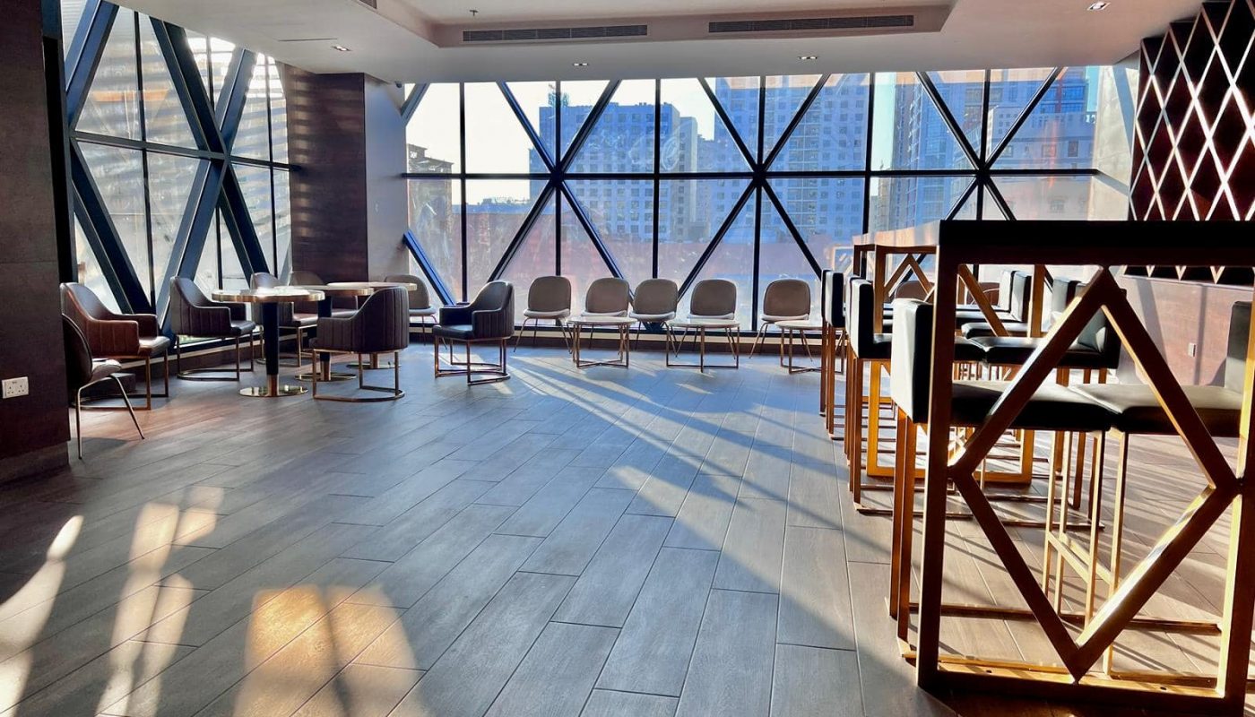 A luxury hotel lobby in Juffair with large windows overlooking a city.