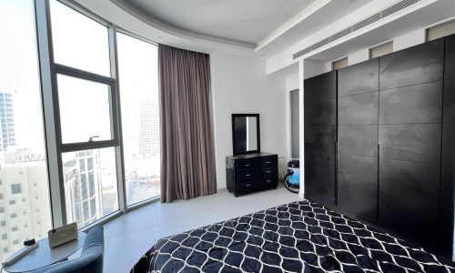 A luxurious apartment with a large window offering a panoramic city view.