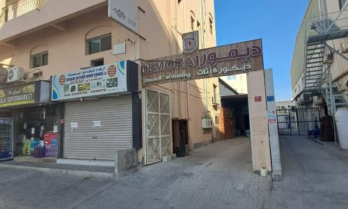 An auto repair shop on the corner of a busy street.