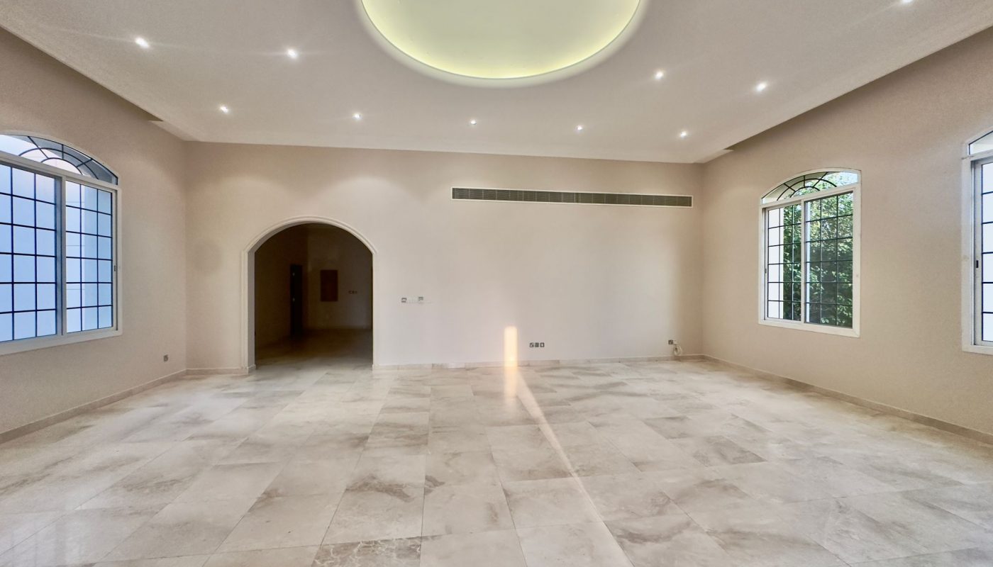 A spacious room with a large arched window.