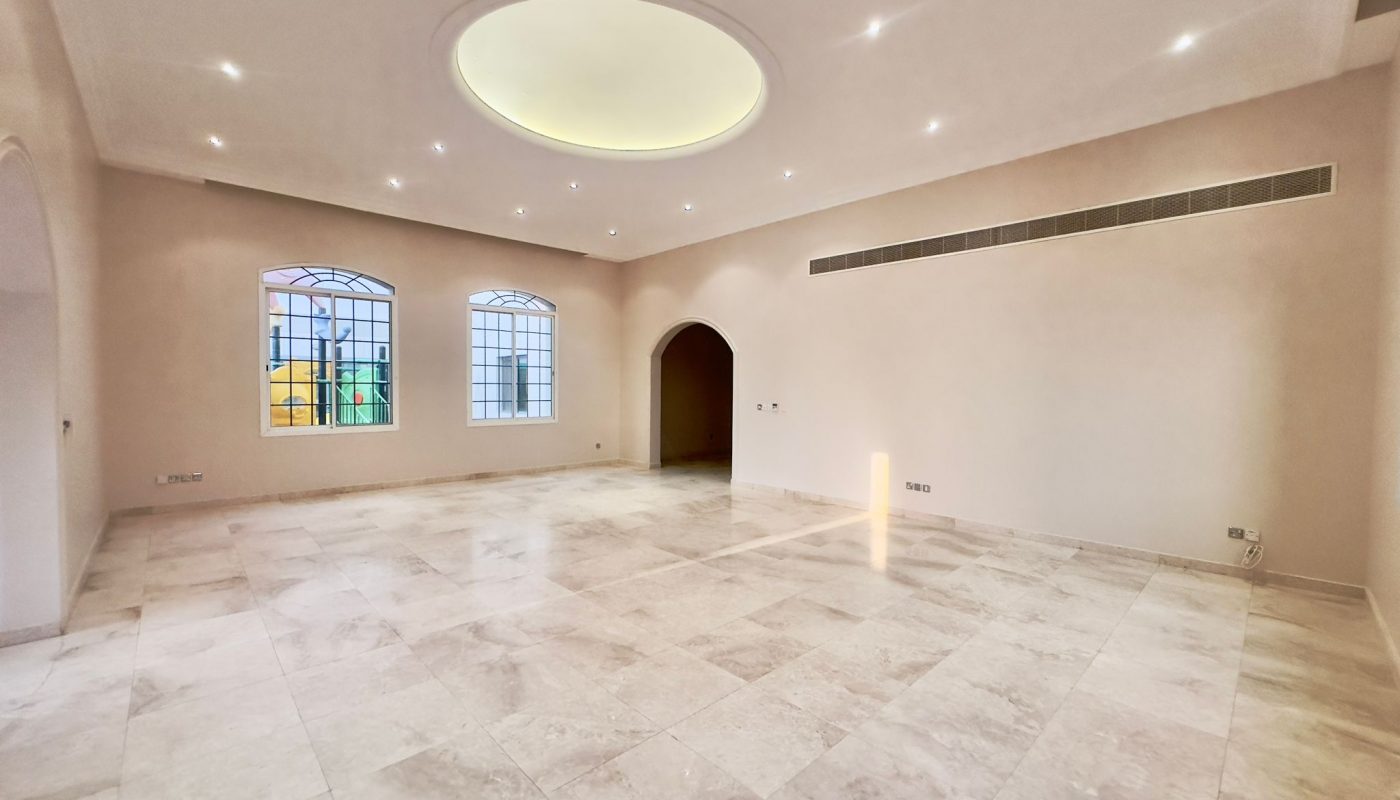 A spacious villa with arched windows and tiled floors.