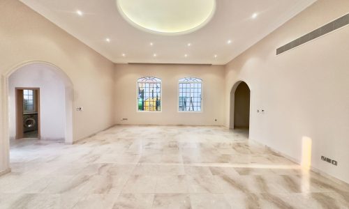 A spacious villa with marble floors and arches.