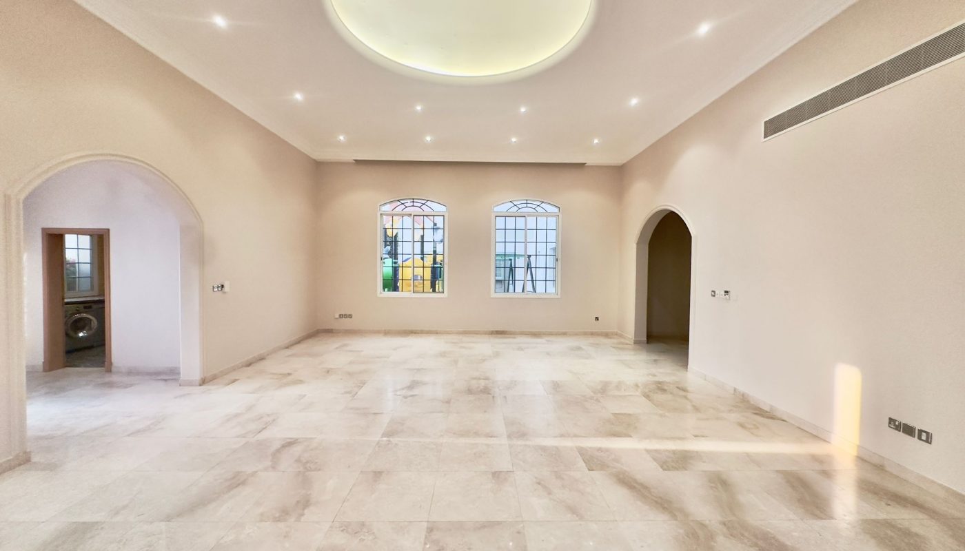 A spacious villa with marble floors and arches.