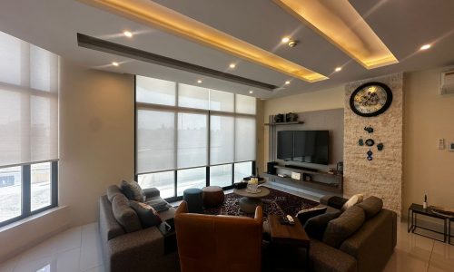 A modern living room with a large flat-screen TV.