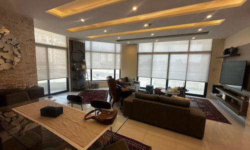 A fully-furnished living room with furniture and a flat screen tv in a luxury modern apartment.