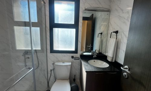 A luxury modern apartment in Al Janabiyah with a bathroom that includes a toilet, sink, and shower.