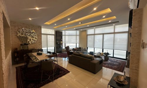 A luxury modern apartment featuring a fully-furnished living room and dining room in Al Janabiyah.