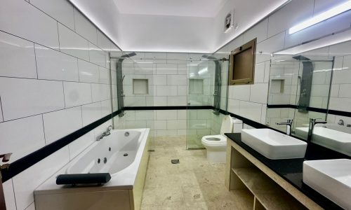 A luxurious bathroom with two sinks and a bathtub, located in a private villa with 4 bedrooms and a private pool.