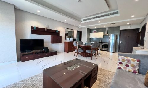 A furnished living room and kitchen area in a luxury modern apartment located in Juffair.