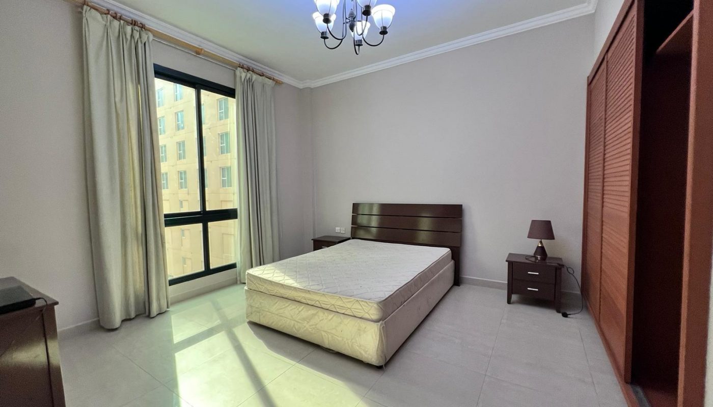 A bedroom with a bed and a dresser.