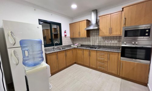 A kitchen with stainless steel appliances and wooden cabinets.