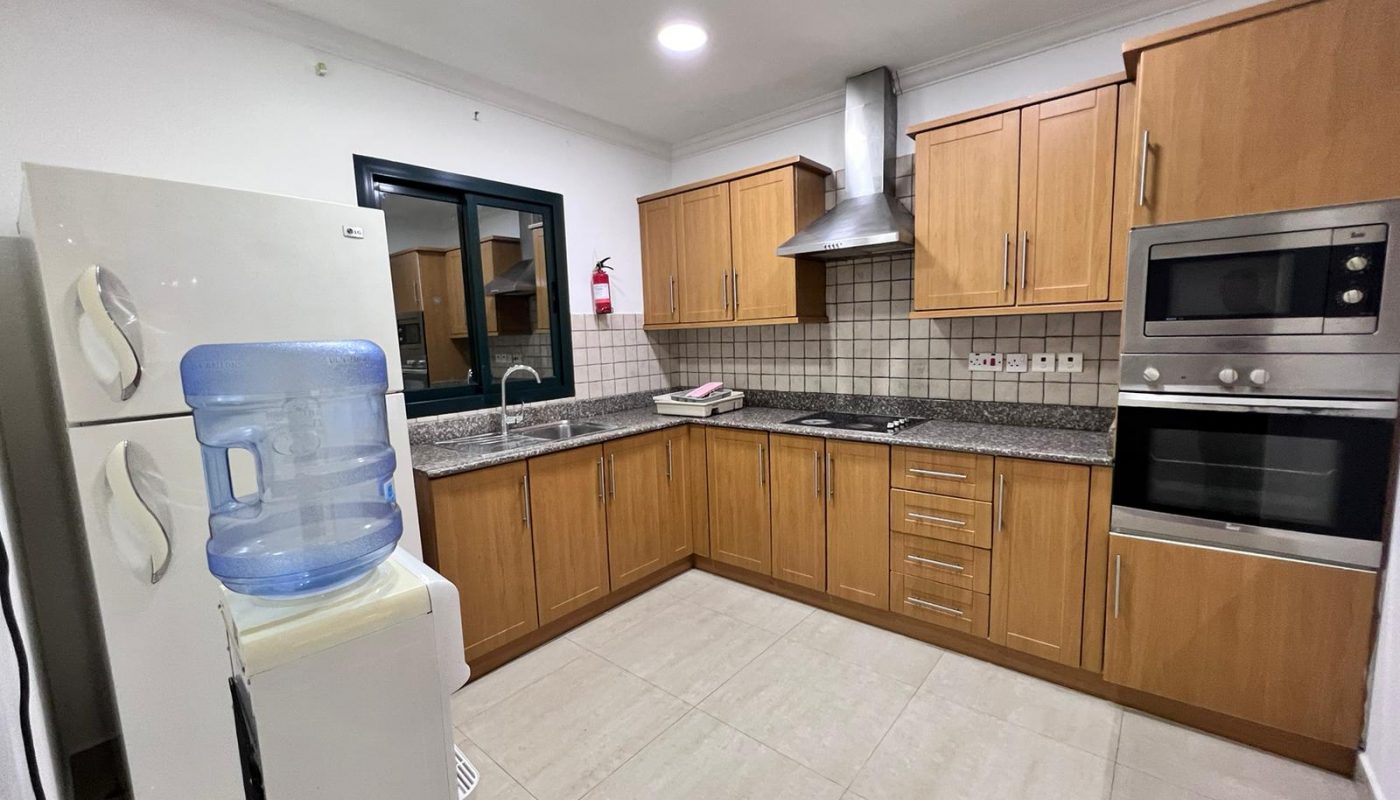 A kitchen with stainless steel appliances and wooden cabinets.