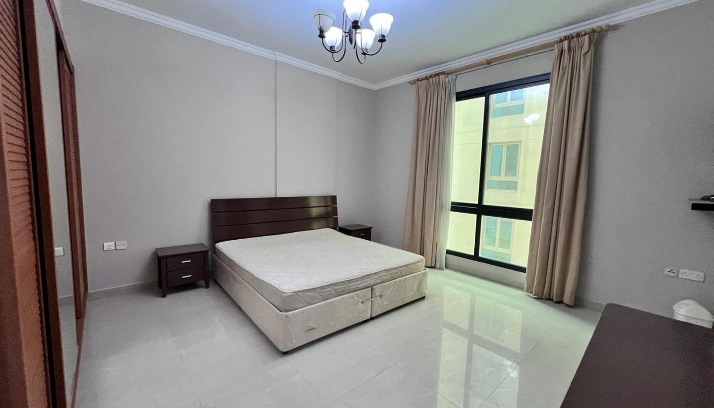 A bedroom with a bed and a dresser.