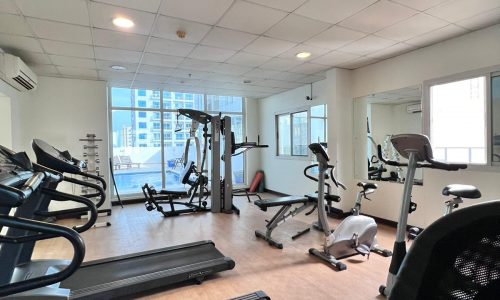 A gym room with treadmills and auto draft machines.