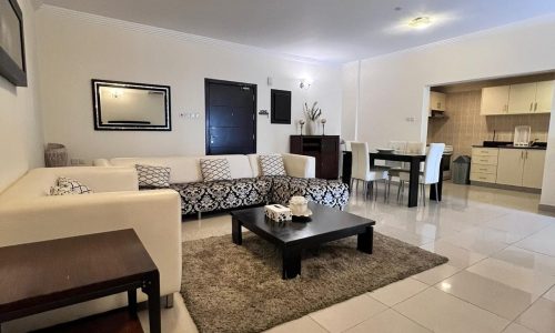 A living room with white furniture and a coffee table designed for relaxation.