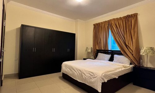 A cozy bedroom featuring a comfortable bed and a sleek bedside table.