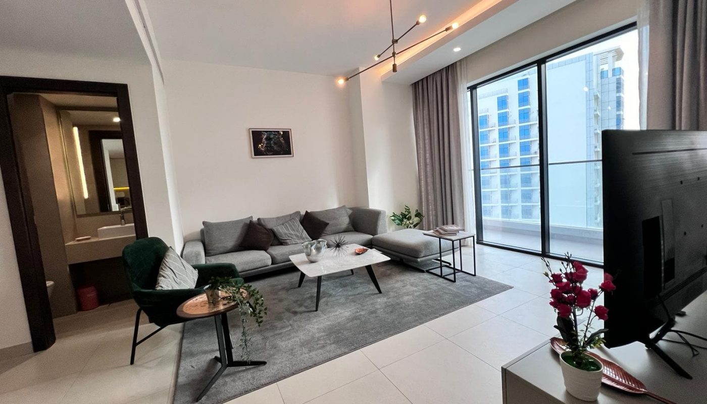 A luxury 1BR apartment in Juffair with a flat screen tv and a balcony.