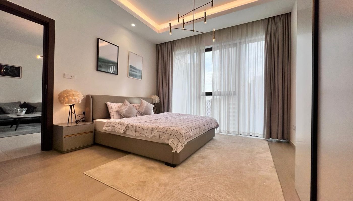 A luxury bedroom in a 1BR apartment, complete with a plush bed and a stylish bedside table.
