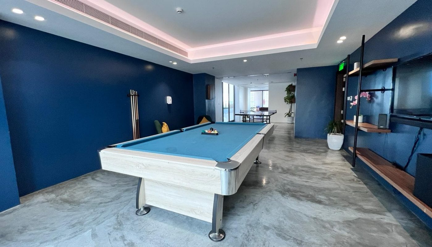 A Luxury 1BR Apartment in Juffair with Exceptional Amenities, featuring a pool table in a room with blue walls.