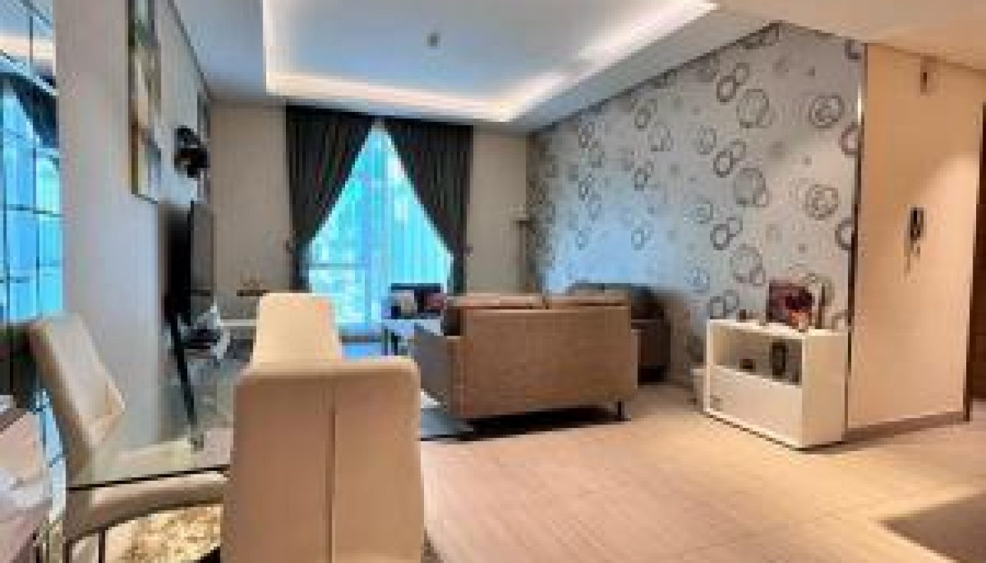 Modern living and dining area with beige tiled floors, a patterned accent wall, large windows with curtains, and contemporary furniture.