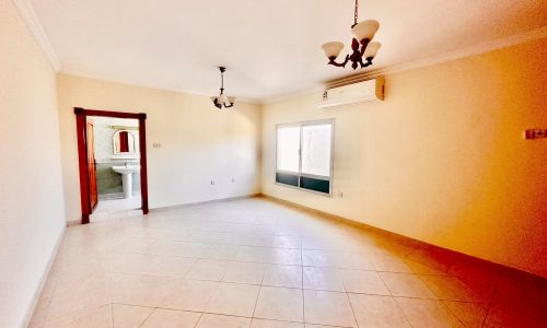 A rented villa in a green compound with tiled floors and a ceiling fan.