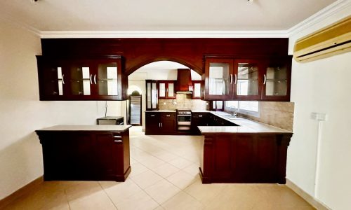 A Janusan villa with wooden cabinets and a tiled floor.